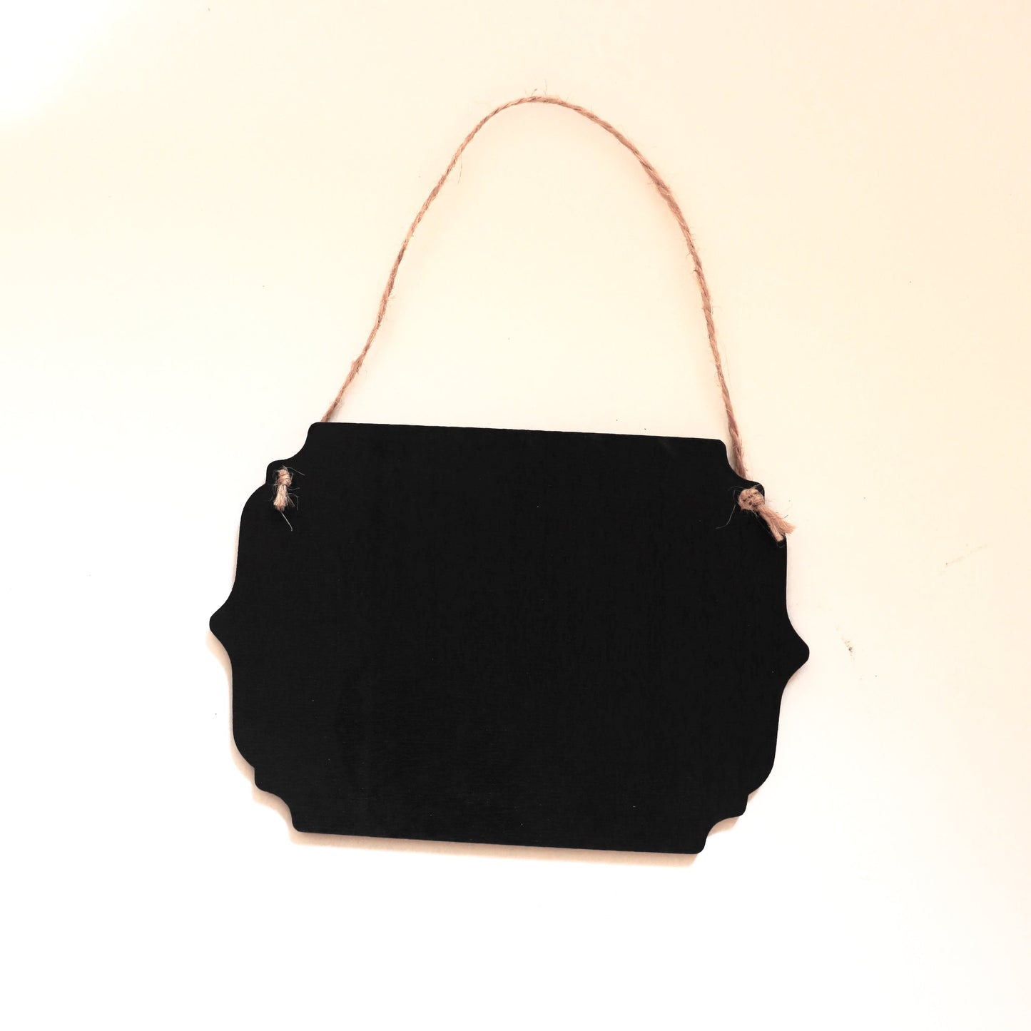 schwarzes Hängeschild mit Jutekordel von der Rückseite auf weißem Hintergrund